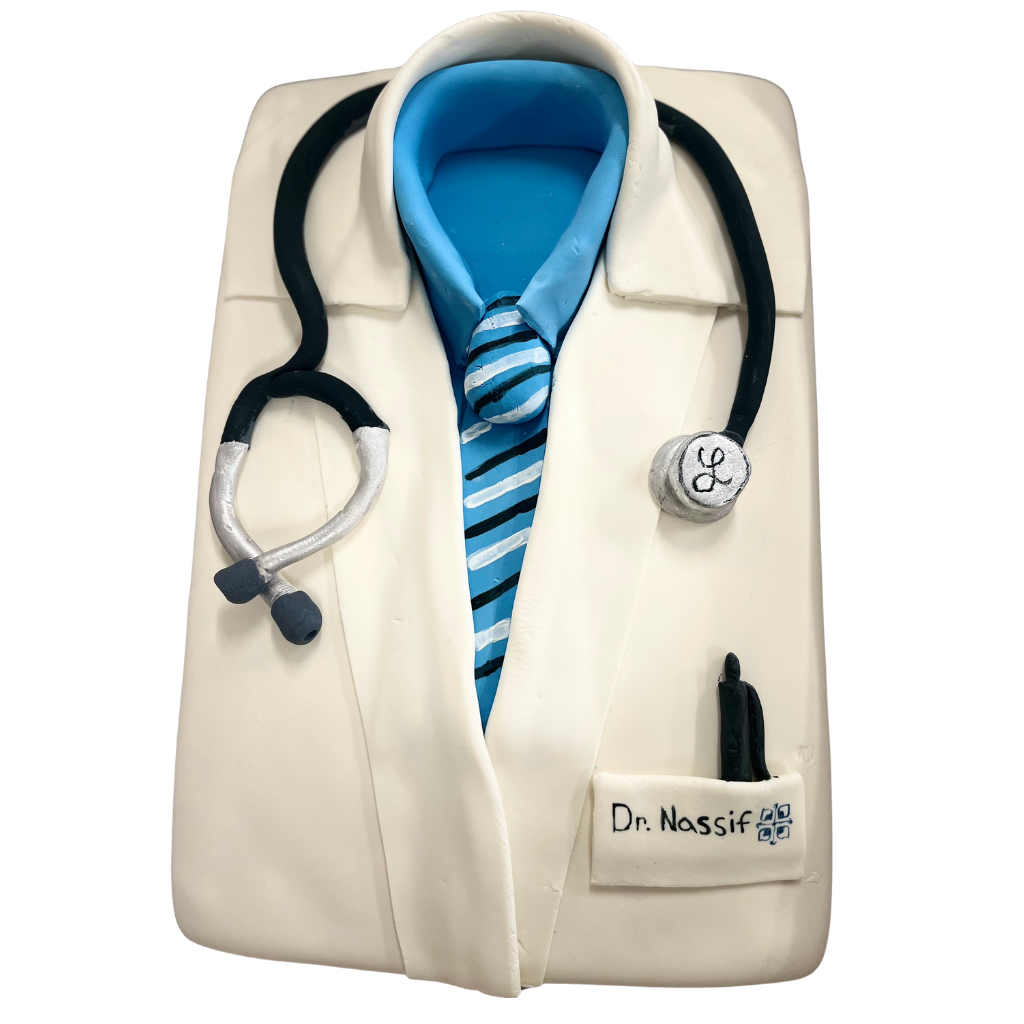 Sheet cake carved and decorated as a white doctor's lab coat with a tie and stethoscope