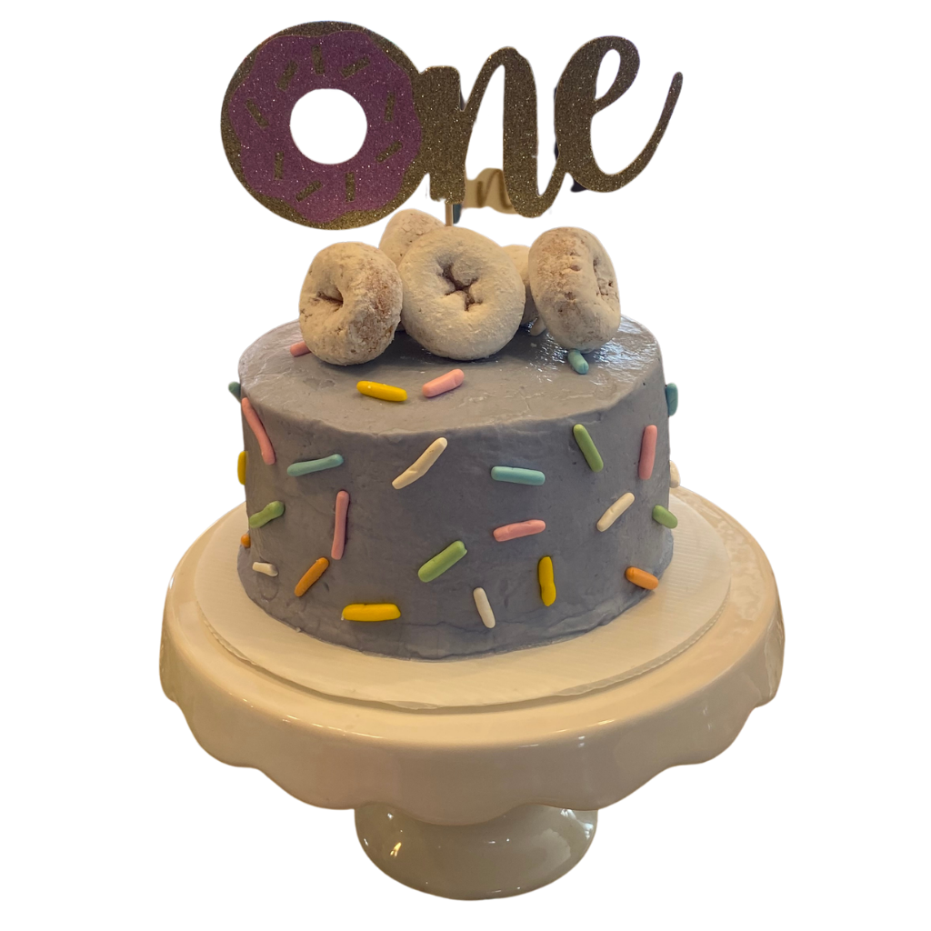 Round lavender buttercream cake with pastel sprinkles and cake donuts on top
