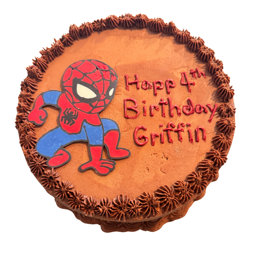 Round chocolate buttercream birthday cake with a fondant superhero figure and piped star borders