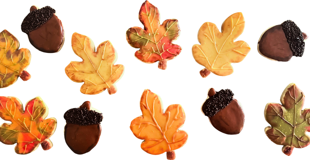 Fall cookies shaped like maple leaves and chocolate acorns