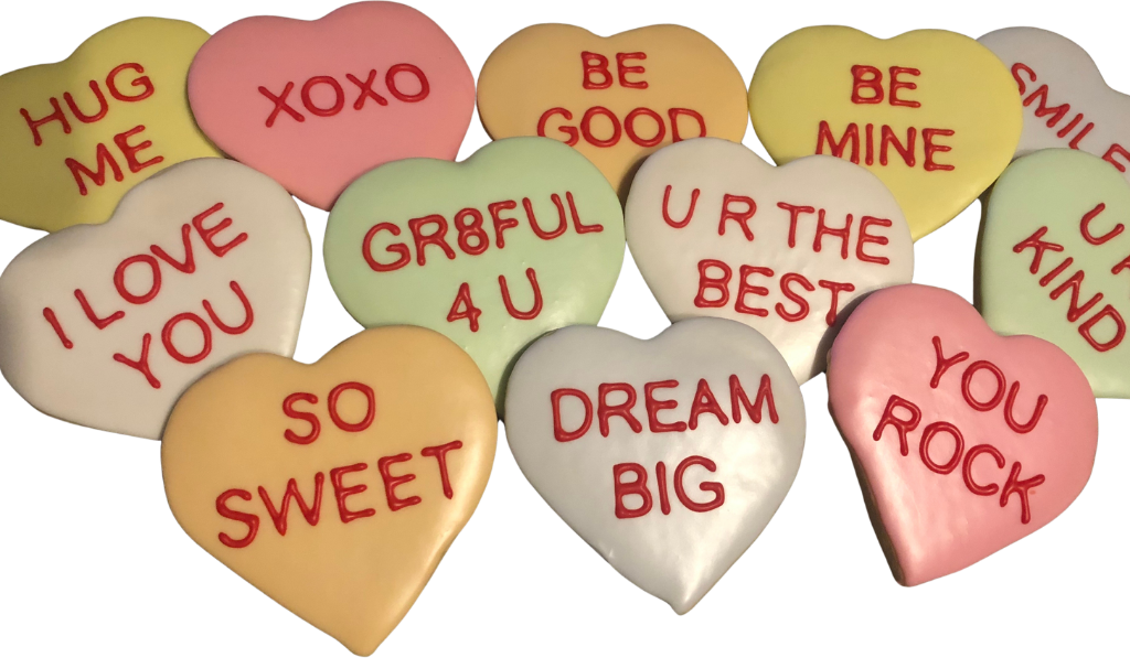 Valentine's conversation heart cookies in pink, yellow, green and white with red lettering