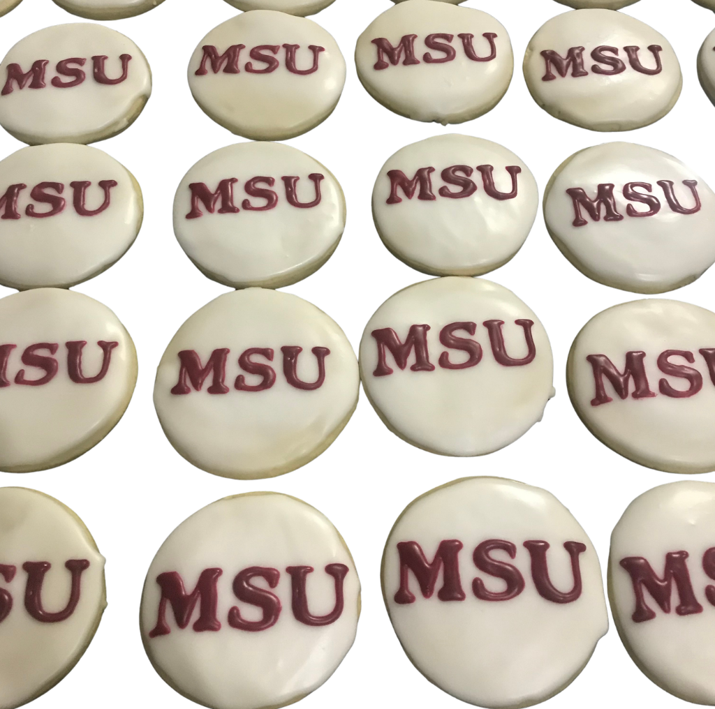 Rows of round white cookies lettered MSU in maroon icing